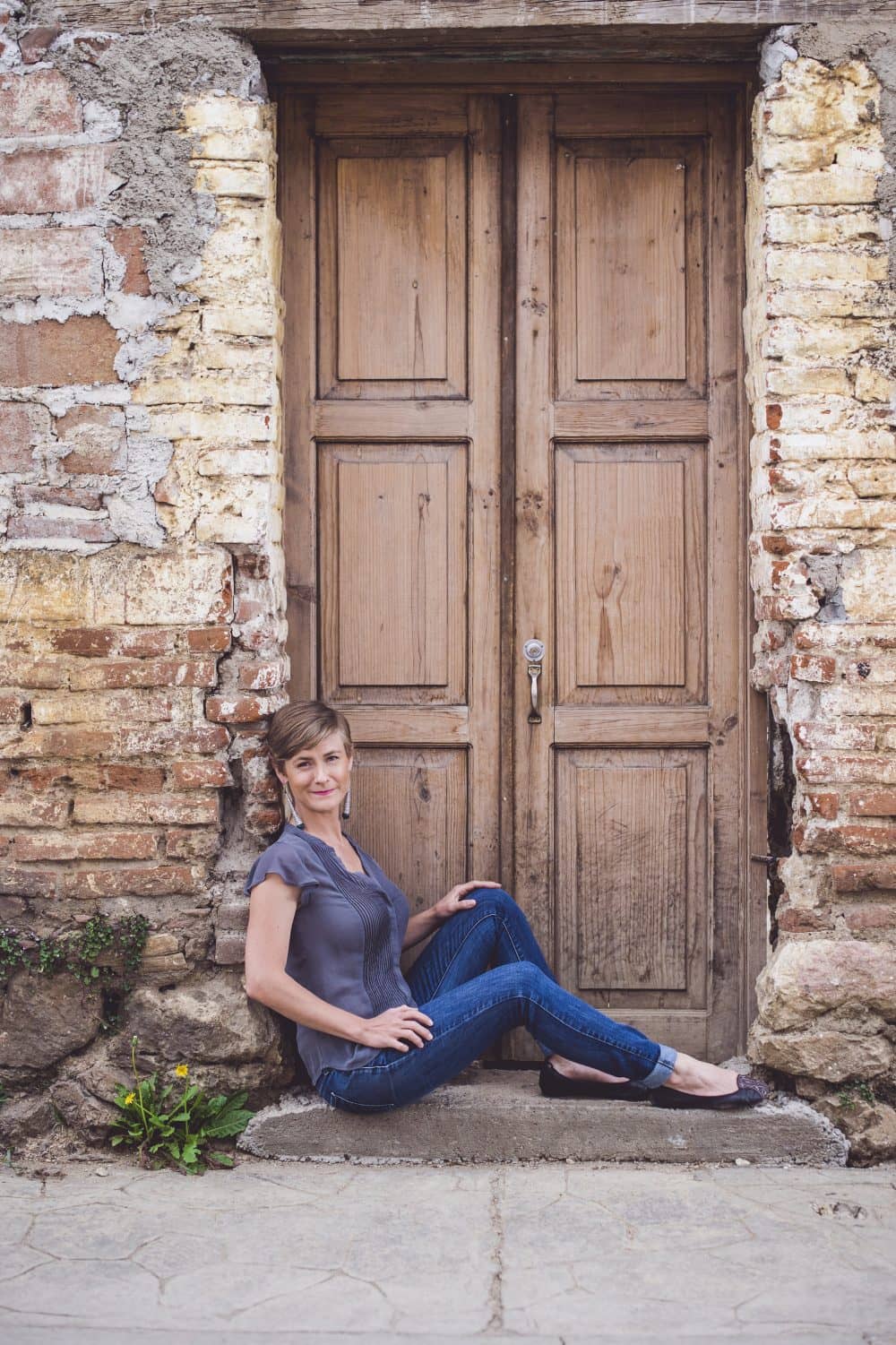 Ava is sitiing in a doorway in San Cristobal de Las Casas, inviting women to seek online empowerment coaching